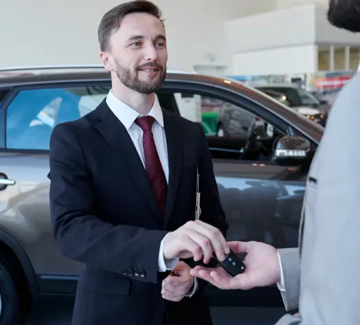 Coverage for Test Drives Car salesman handing keys to customer