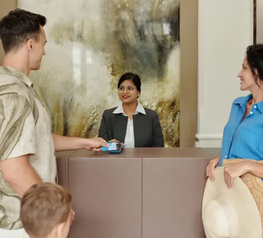 Personalized Hotel Insurance Coverage Hotel front desk with staff assisting guest