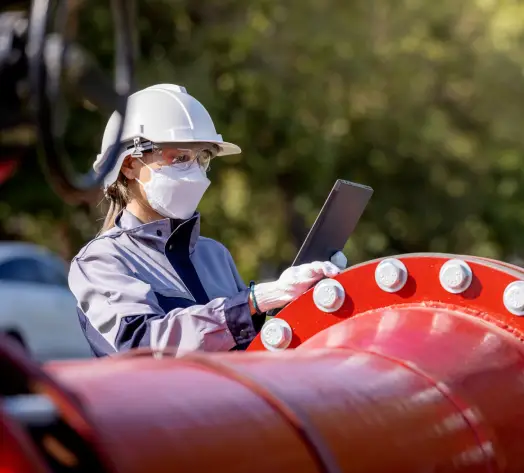 Liability and Safety Coverage for Energy Teams Worker inspecting pipeline with safety gear