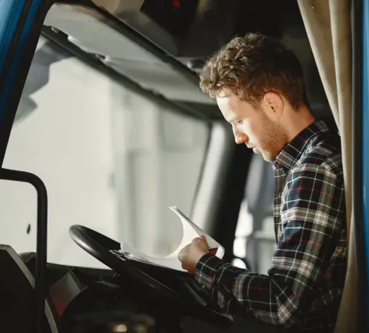 Coverage for Local and Long-Haul Drivers Truck driver reviewing delivery schedule