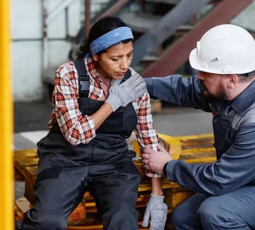 Workers Comp Coverage for On-the-Job Injuries Employee holding injured wrist with supervisor nearby